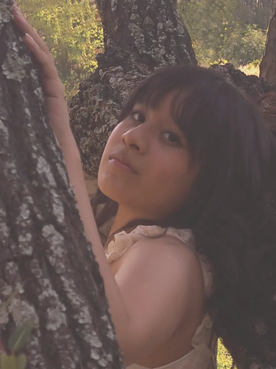 María Andrea mira desde detrás de un árbol